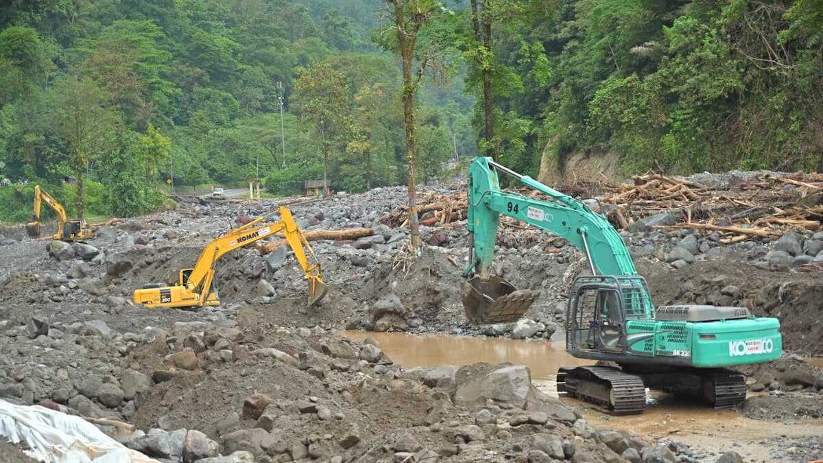 Alat berat sedang membersihkan material banjir bandang. (dok. istimewa)