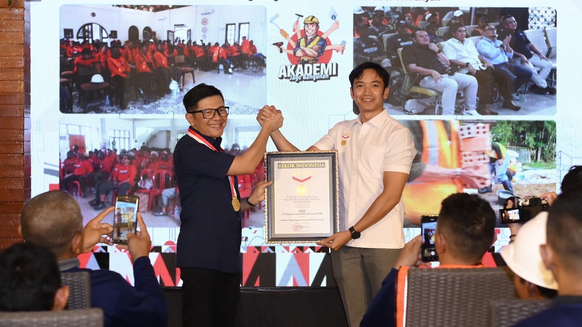 Direktur Sales dan Marketing SIG, Dicky Saelan (kiri) menerima Piagam Penghargaan Museum Rekor–Dunia Indonesia (MURI) atas Rekor Pelatihan Tukang Bangunan Serentak di Provinsi Terbanyak yang diserahkan oleh Senior Manager MURI, Triyono di Sentul, Kabupaten Bogor, Jawa Barat, pada Minggu (1/2/2026). (dok. istimewa)