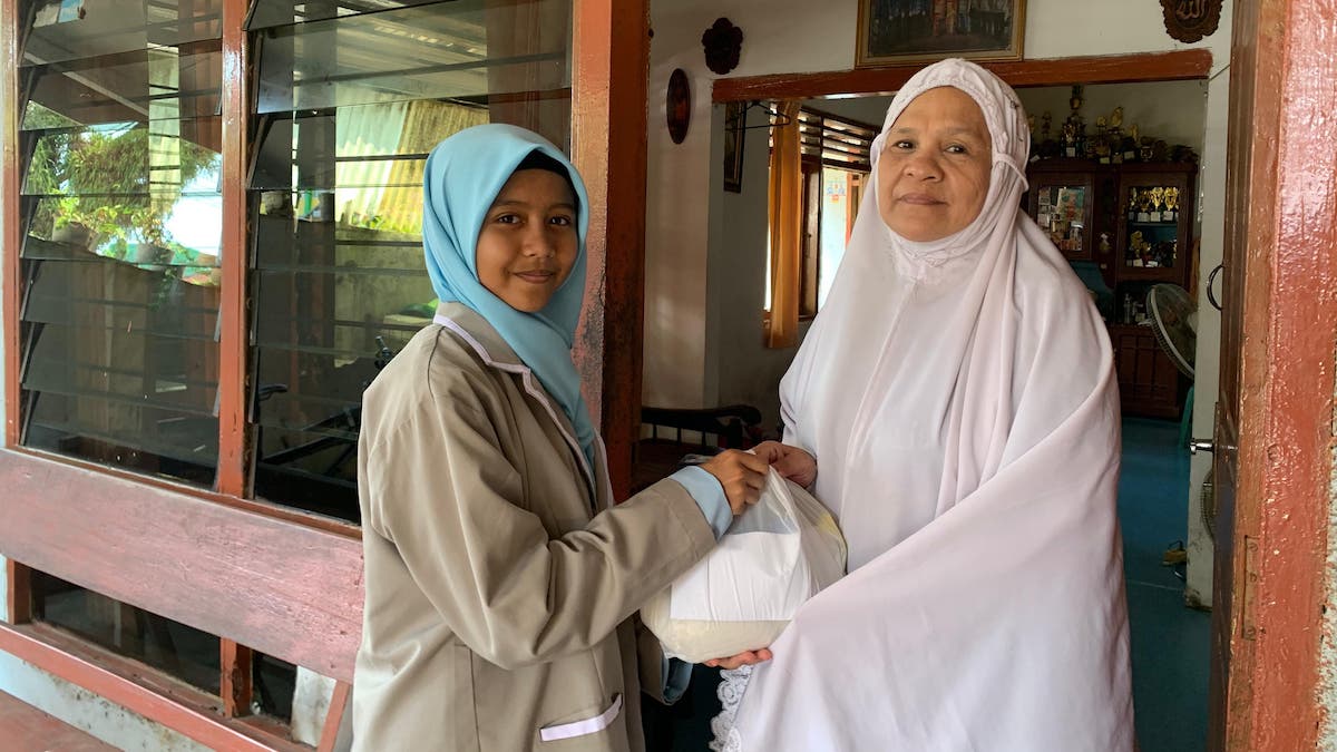 Ketua OSIS SMPN 2 Pariaman, Hafidzah Zhafira Indra serahkan sembako untuk warga. (dok. istimewa)
