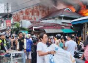 Para pedagang korban kebakaran 17 unit rumah toko (ruko) di Lingkungan I, Kelurahan Pasar, Kota Gunungsitoli, Sumut berupaya menyelamatkan barang di tengah kobaran api, Kamis (10/4/2026) sore. (Putra/Radar Sumbar).