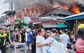 Para pedagang korban kebakaran 17 unit rumah toko (ruko) di Lingkungan I, Kelurahan Pasar, Kota Gunungsitoli, Sumut berupaya menyelamatkan barang di tengah kobaran api, Kamis (10/4/2026) sore. (Putra/Radar Sumbar).