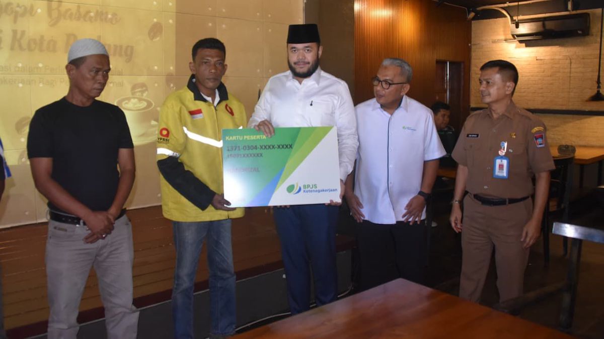 Wako Fadly Amran menyerahkan kartu peserta BPJSTK kepada salah seorang ojol saat pertemuan dengan pimpinan perusahaan di Kinol Bistro, Padang. (dok. istimewa)